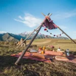 Tipi andino con mantas y pompones para el picnic con llamas frente a los nevados del Valle Sagrado