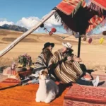 Pareja con ponchos en el picnic con llamas en Maras y Moray